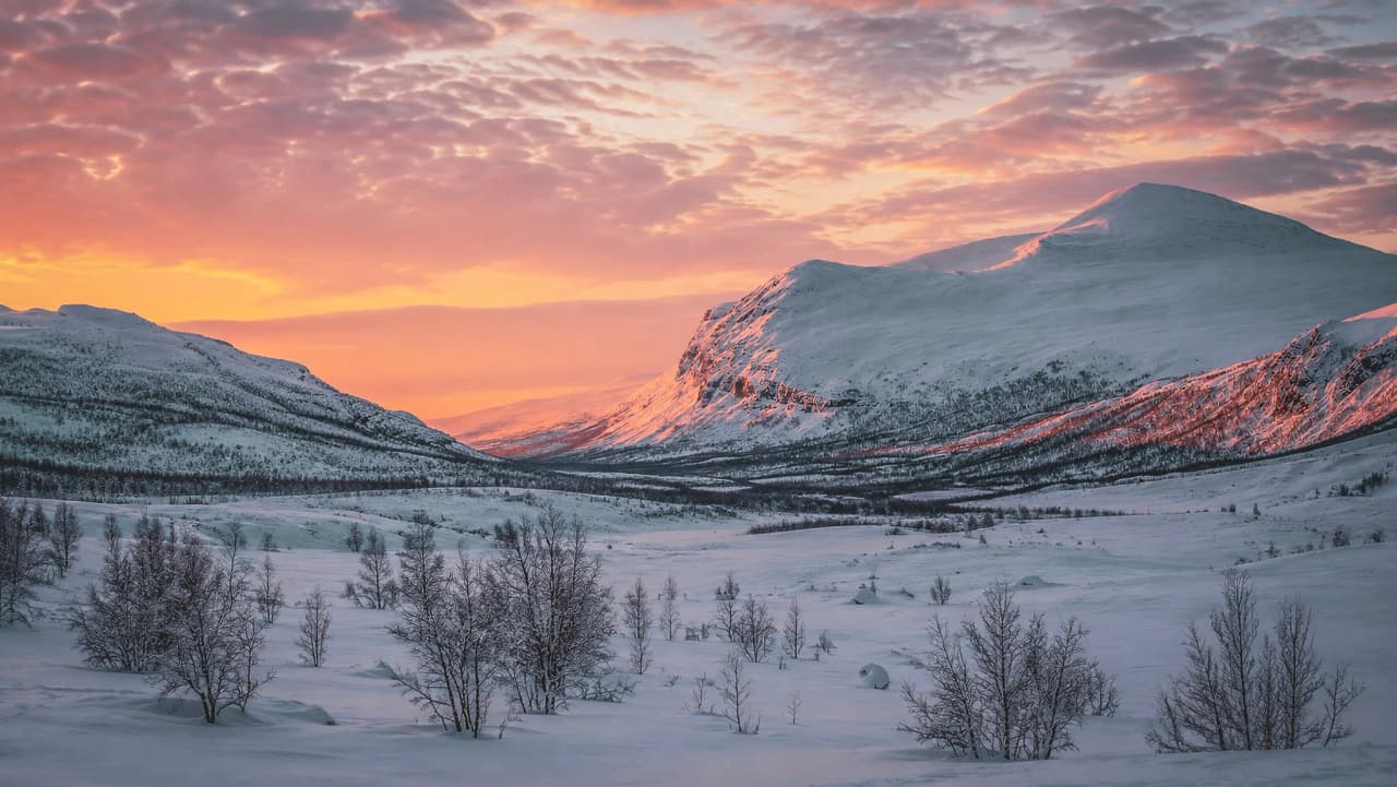 Een betoverende zonsondergang boven de besneeuwde bergen van Lapland, een sprookjesachtige tocht op langlaufski’s.