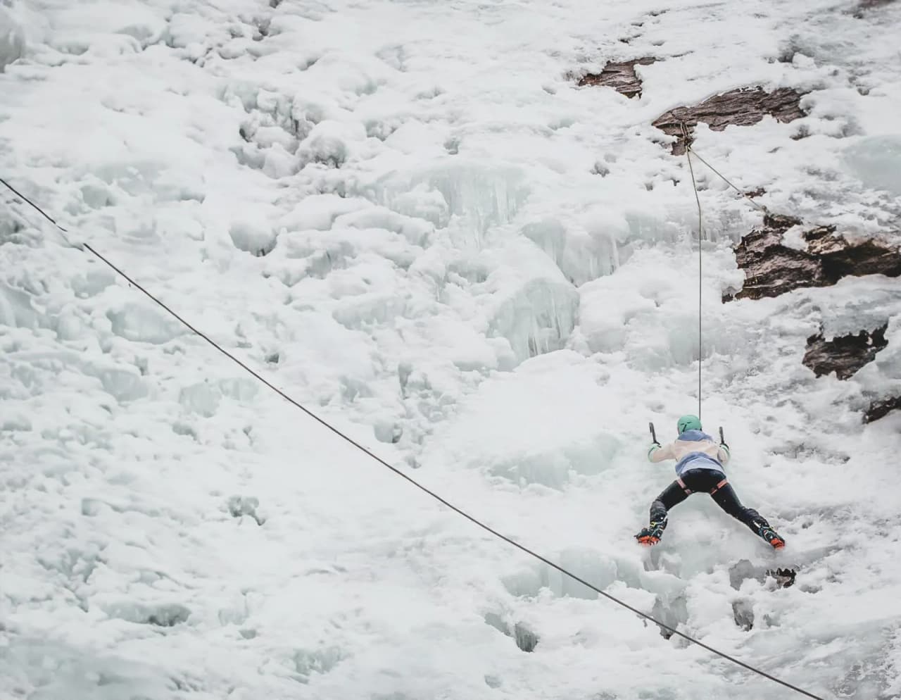 Un grimpeur s'attaque à une cascade de glace majestueuse dans les Alpes italiennes.