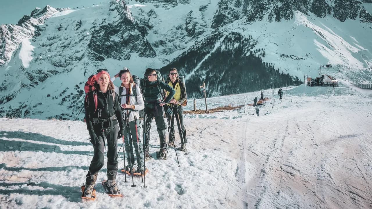 A happy group on snowshoes in a snow-covered Alpine landscape, ready for adventure.