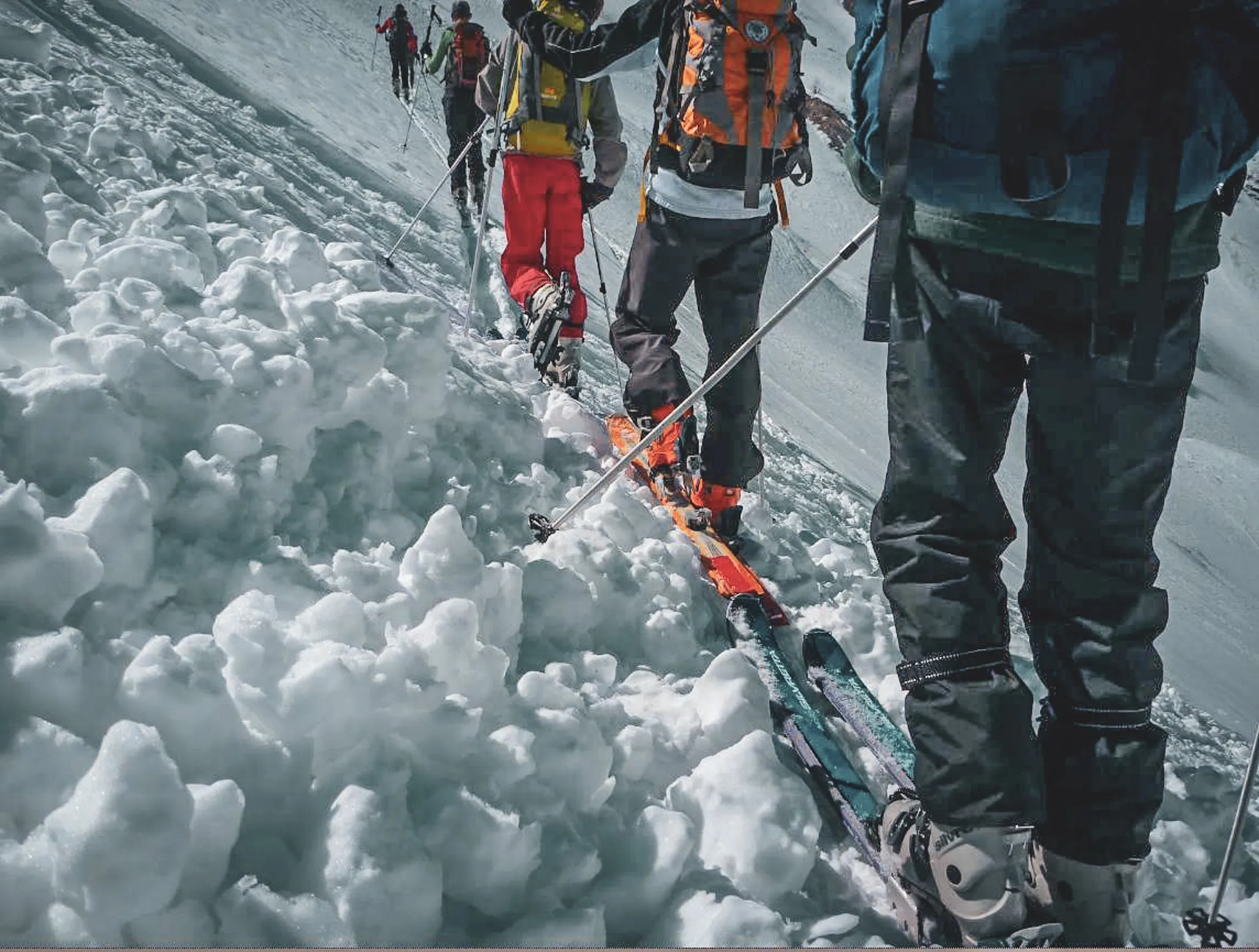 Een groep skiërs op een gletsjer, omringd door schitterende sneeuw en Alpenlandschap.