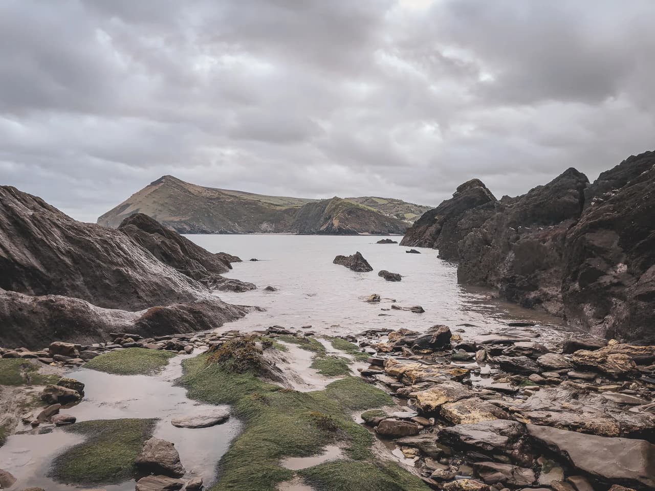 Côte sauvage galloise avec rochers et mer calme, idéale pour une aventure en croisière.