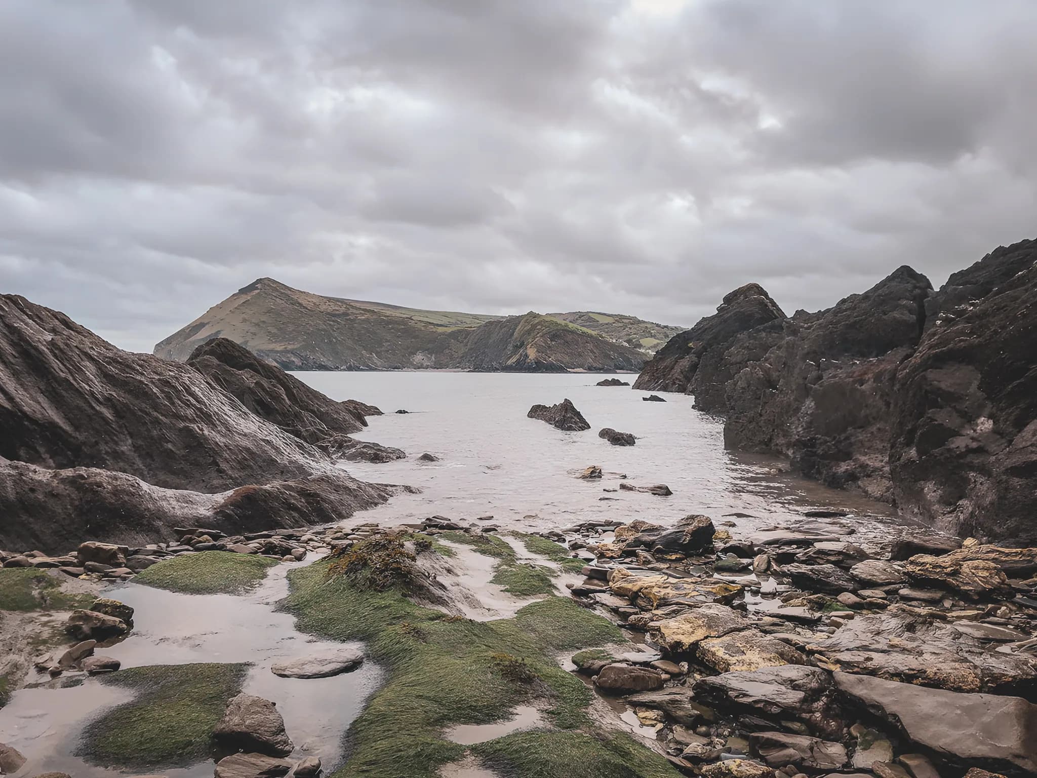 Côte sauvage galloise avec rochers et mer calme, idéale pour une aventure en croisière.