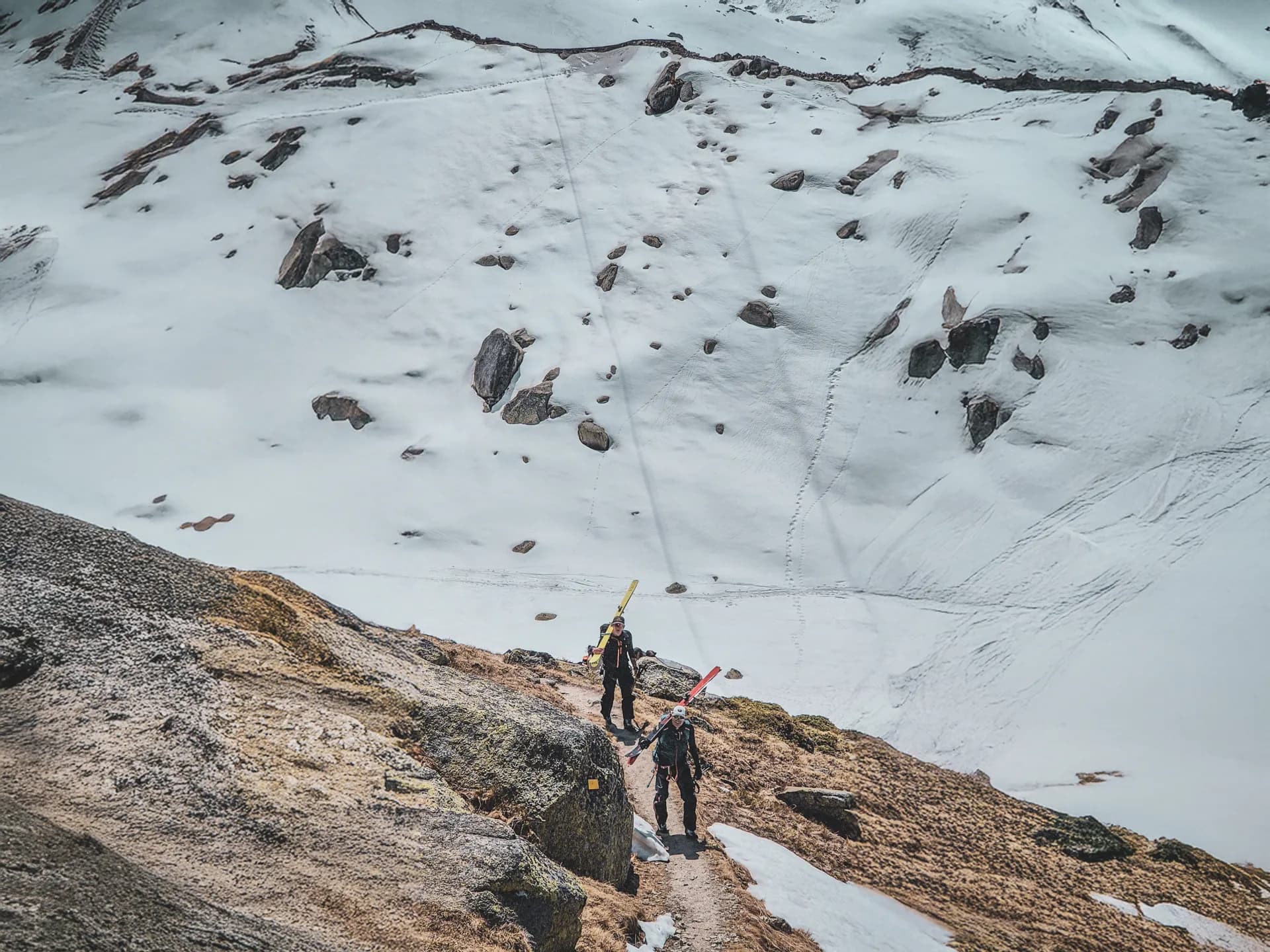 Twee skitourers doorkruisen een besneeuwd berglandschap, klaar om de Mont Blanc te beklimmen.