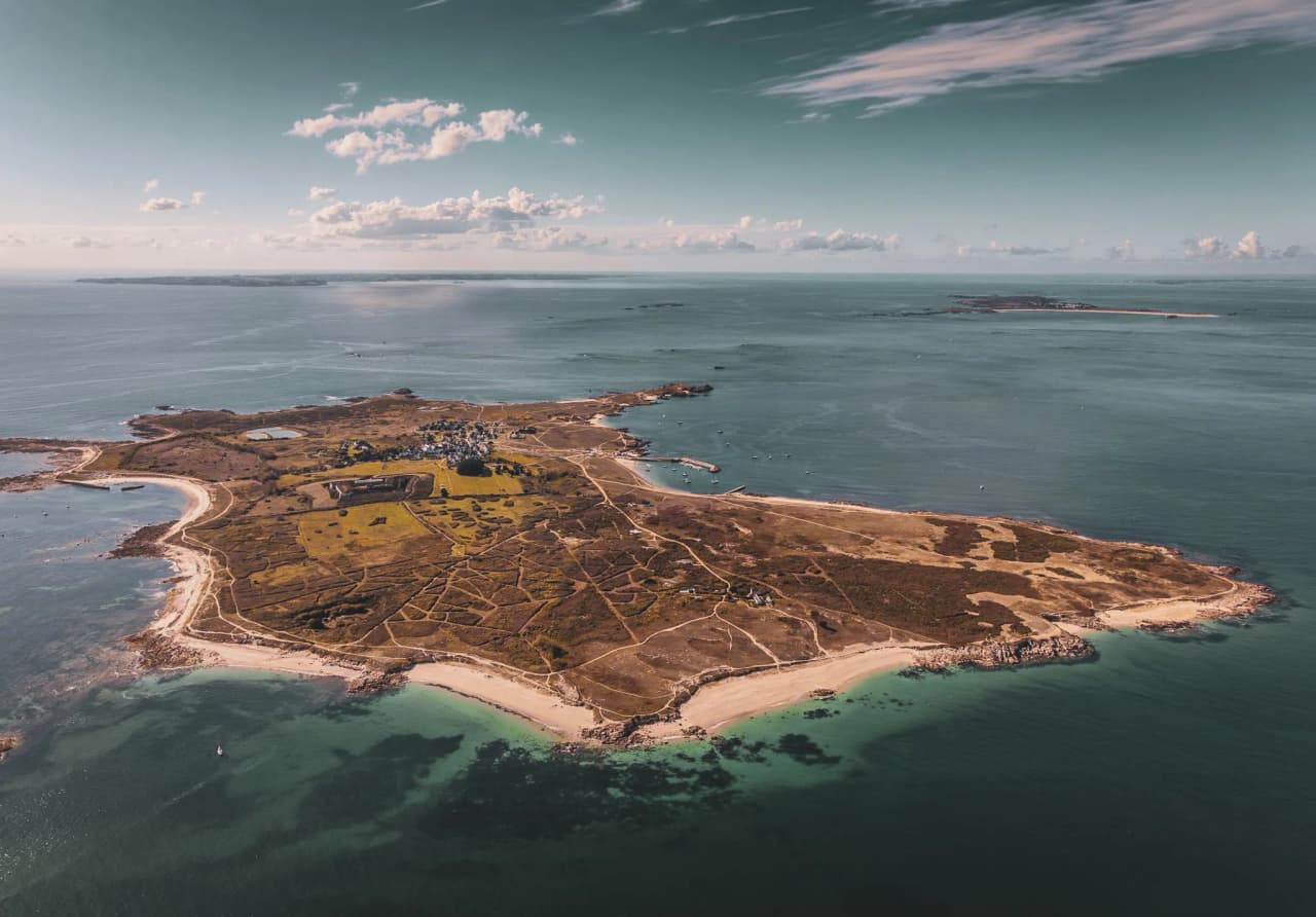 A coastal island bathed in turquoise waters, a wild and peaceful landscape, an invitation to travel.