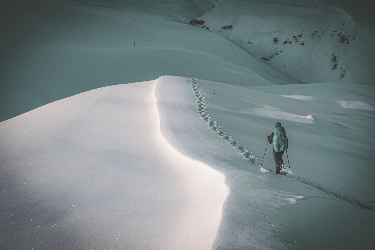 Een eenzame wandelaar doorkruist glinsterende besneeuwde landschappen waar de magie van de winter aan het werk is.