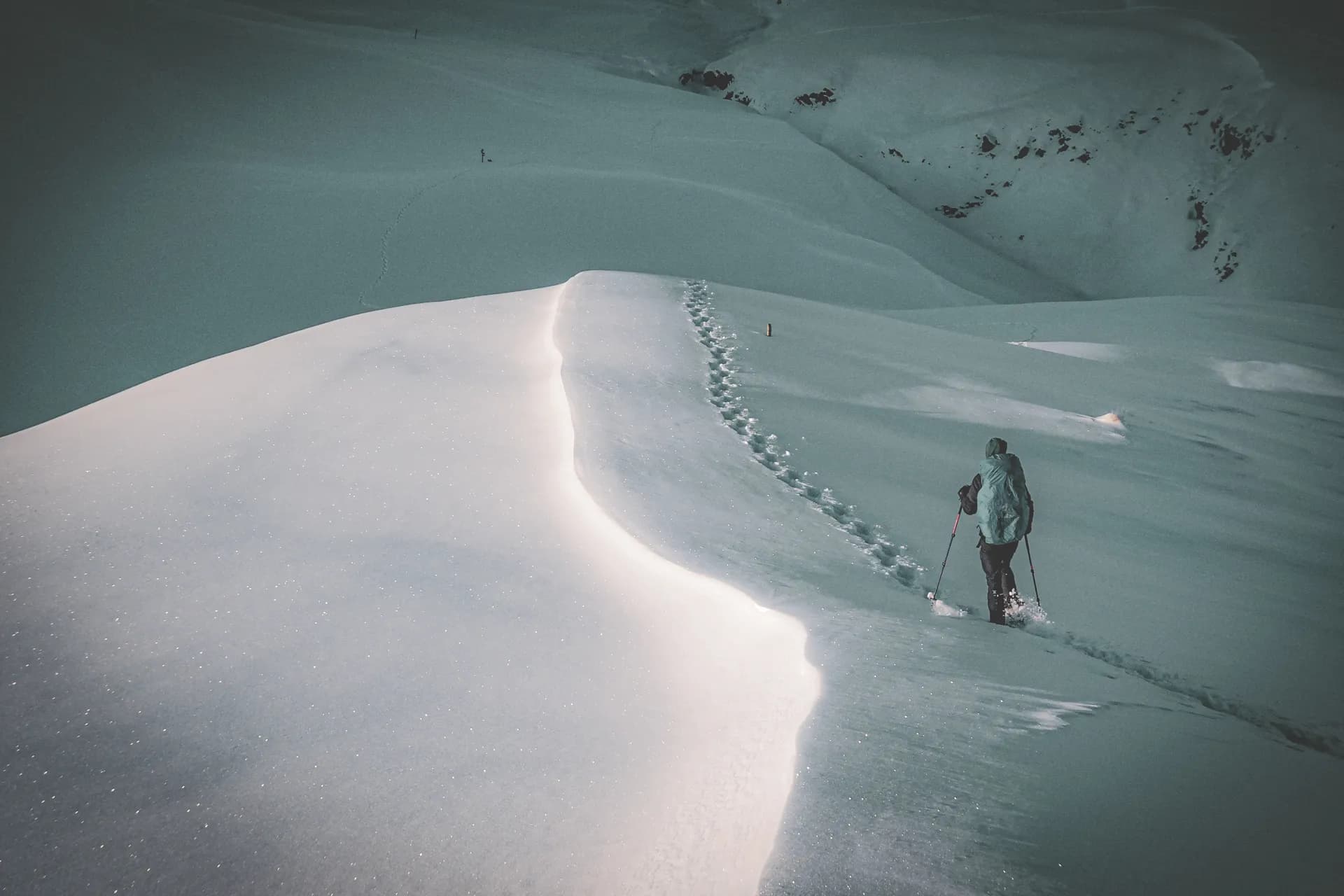 A solitary hiker traverses sparkling snow-covered landscapes where the magic of winter is at work.