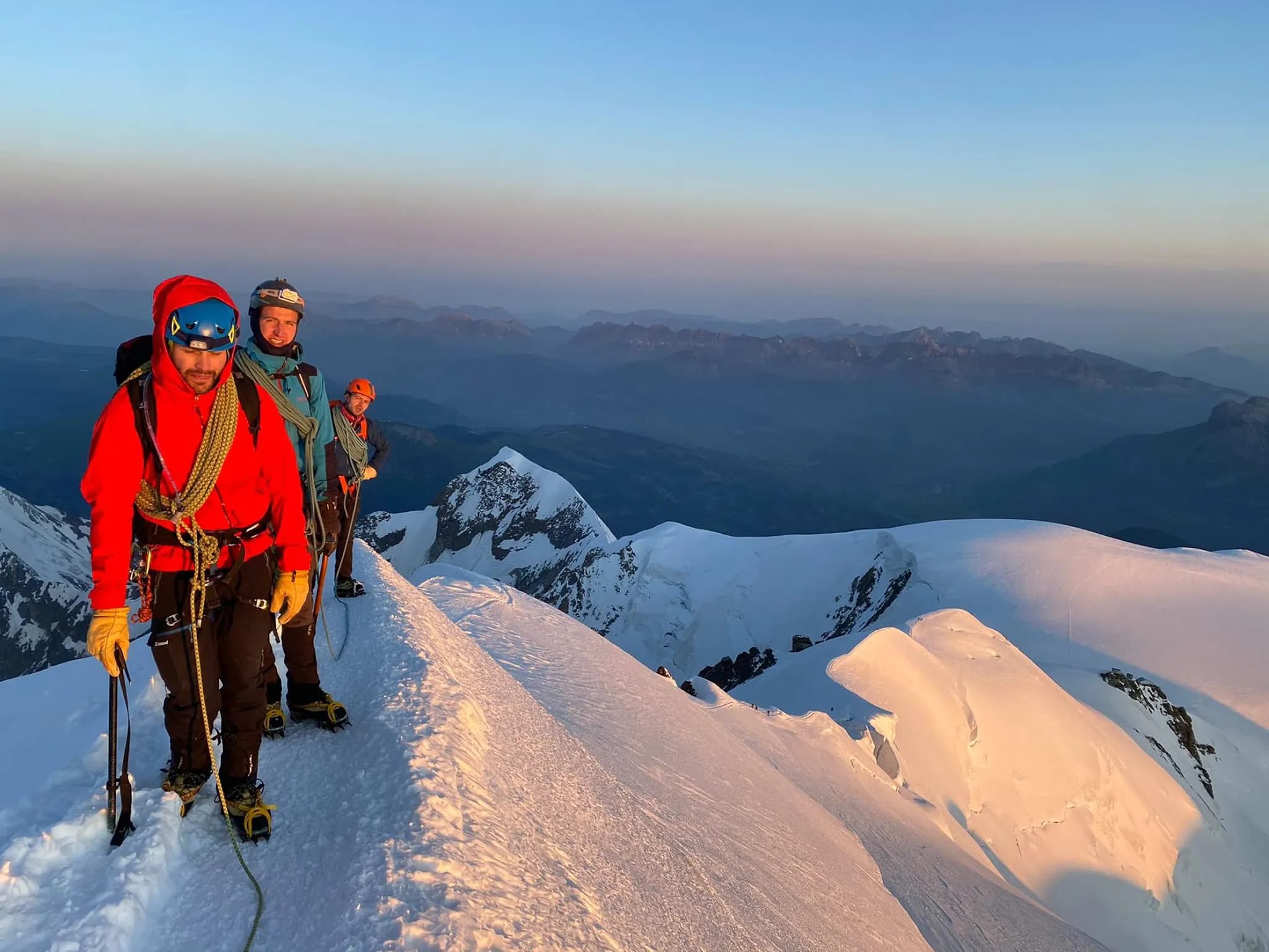 Alpinistes en pleine ascension, silhouette sur un sommet enneigé au lever du soleil. Émerveillement garanti !