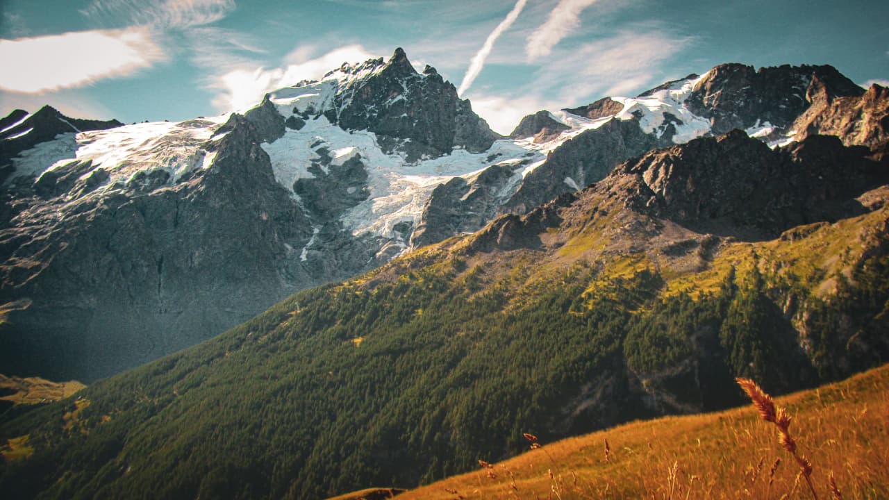 The majestic landscape of the Écrins, with snow-capped mountains and lush green valleys.