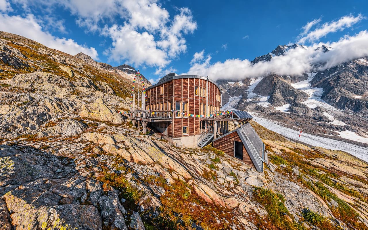 Een moderne Berghut met uitzicht op de majestueuze Dômes de Miage, omgeven door spectaculaire landschappen.