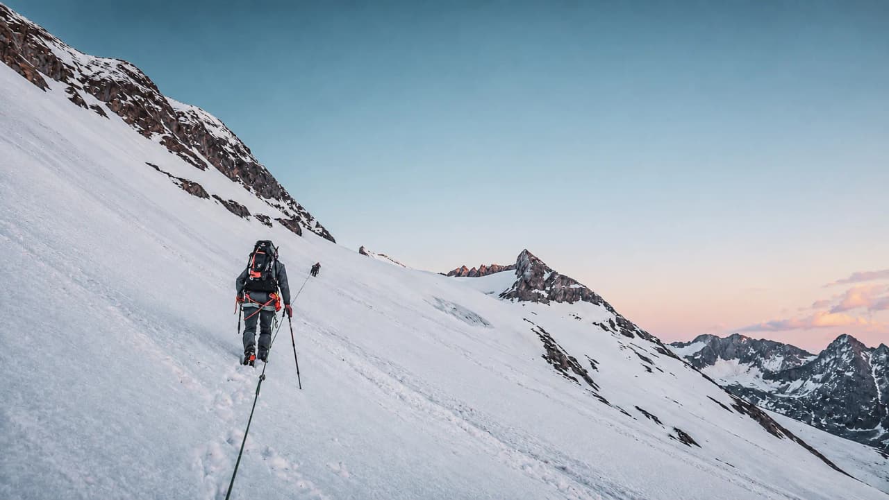 Een bergbeklimming op een gletsjer, onder een heldere hemel, om het alpine avontuur te beleven.