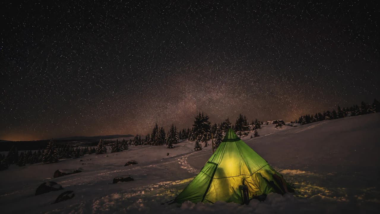 Bivouac sous un tipi illuminé, étoilé dans la Réserve du Vercors, paysage enchanteur.