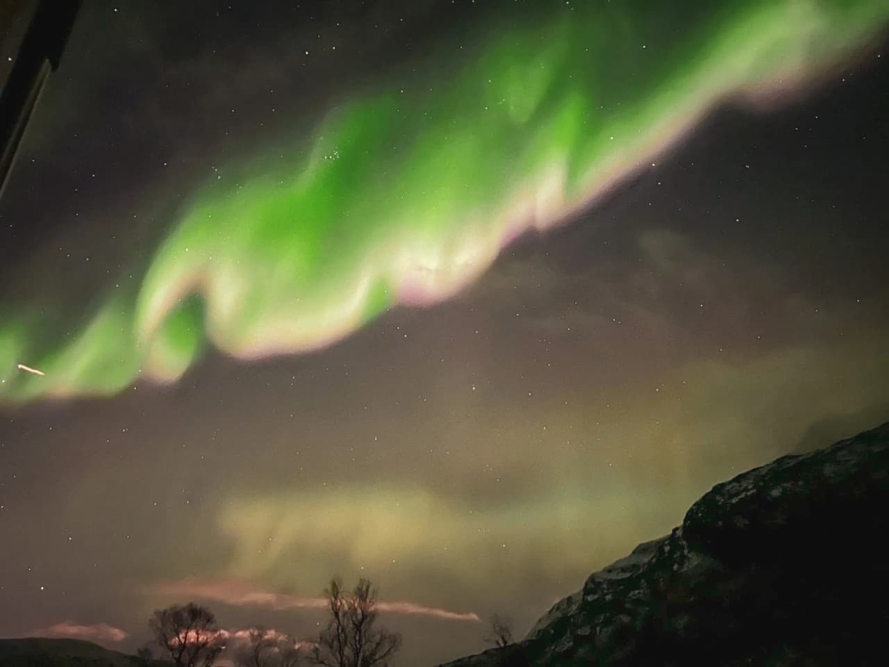 Een majestueus groen noorderlicht dat de nachtelijke hemel boven het Noorse landschap verlicht.