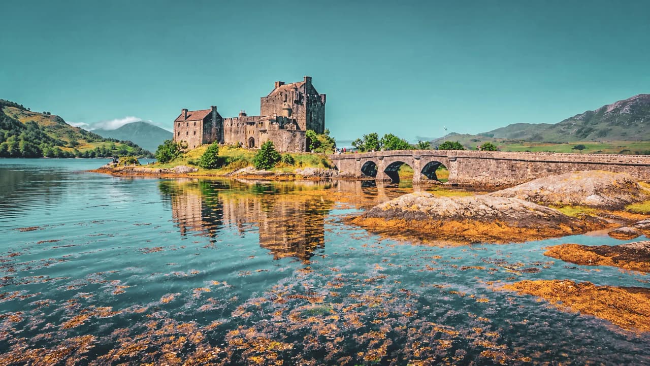 Een pittoresk kasteel op het eiland Skye, omgeven door glinsterend water en weelderige natuur.