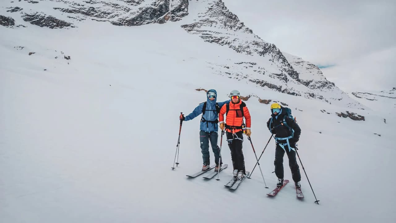 Three skiers on their way up to Gran Paradiso, surrounded by breathtaking Alpine scenery.