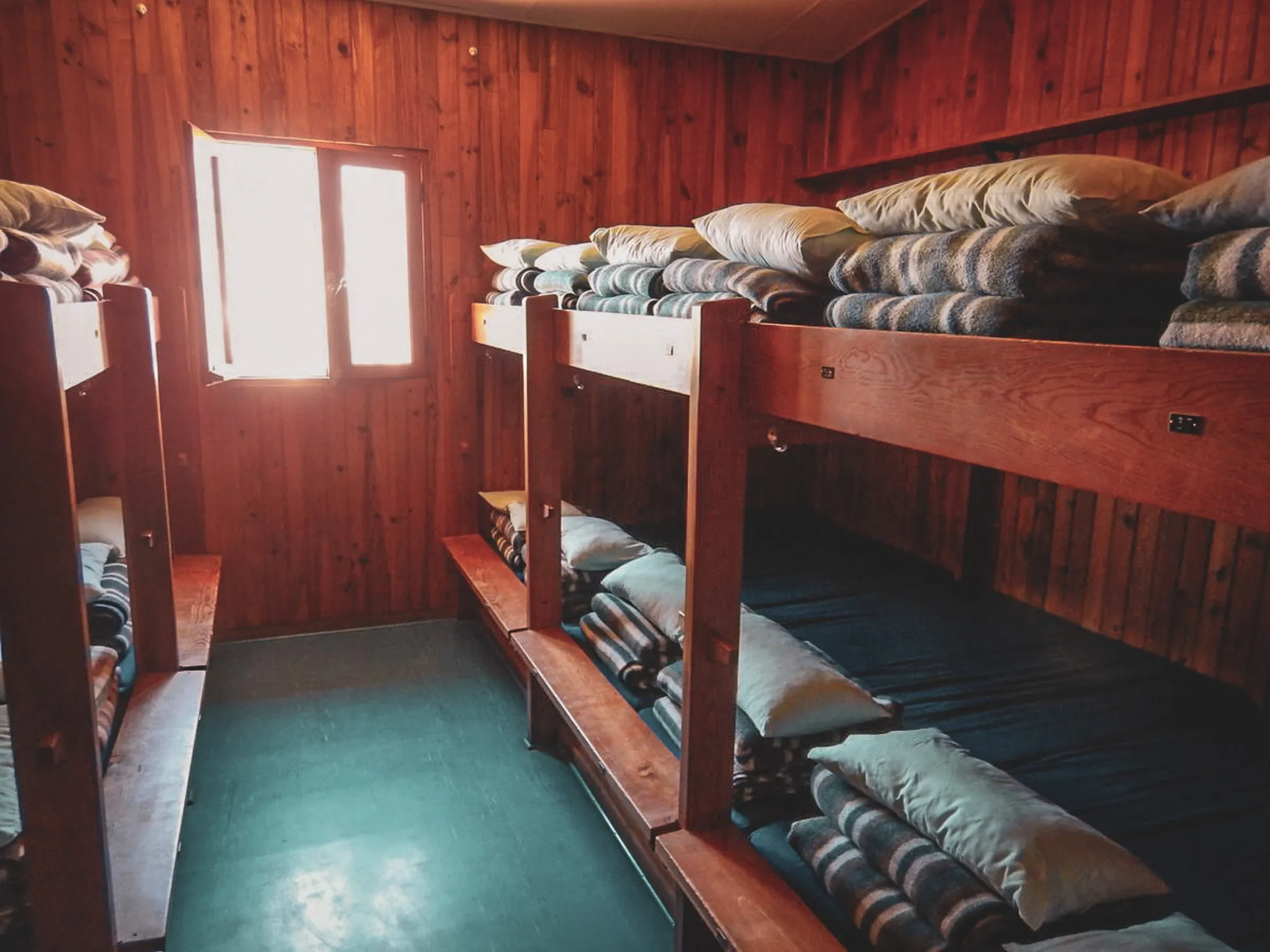 Chambre chaleureuse en bois avec lits superposés, idéale pour l'alpinisme dans les Écrins.