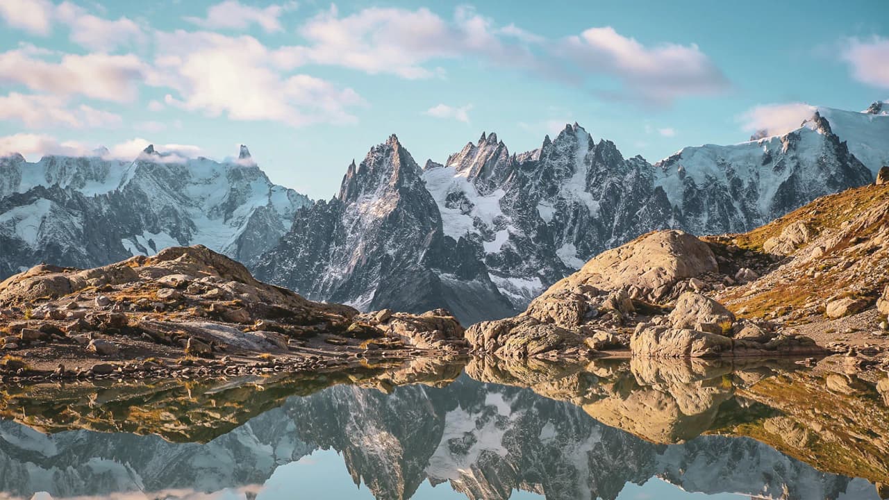 De majestueuze bergen van de Aiguilles Rouges weerspiegeld in een vredig meer, een adembenemend landschap.