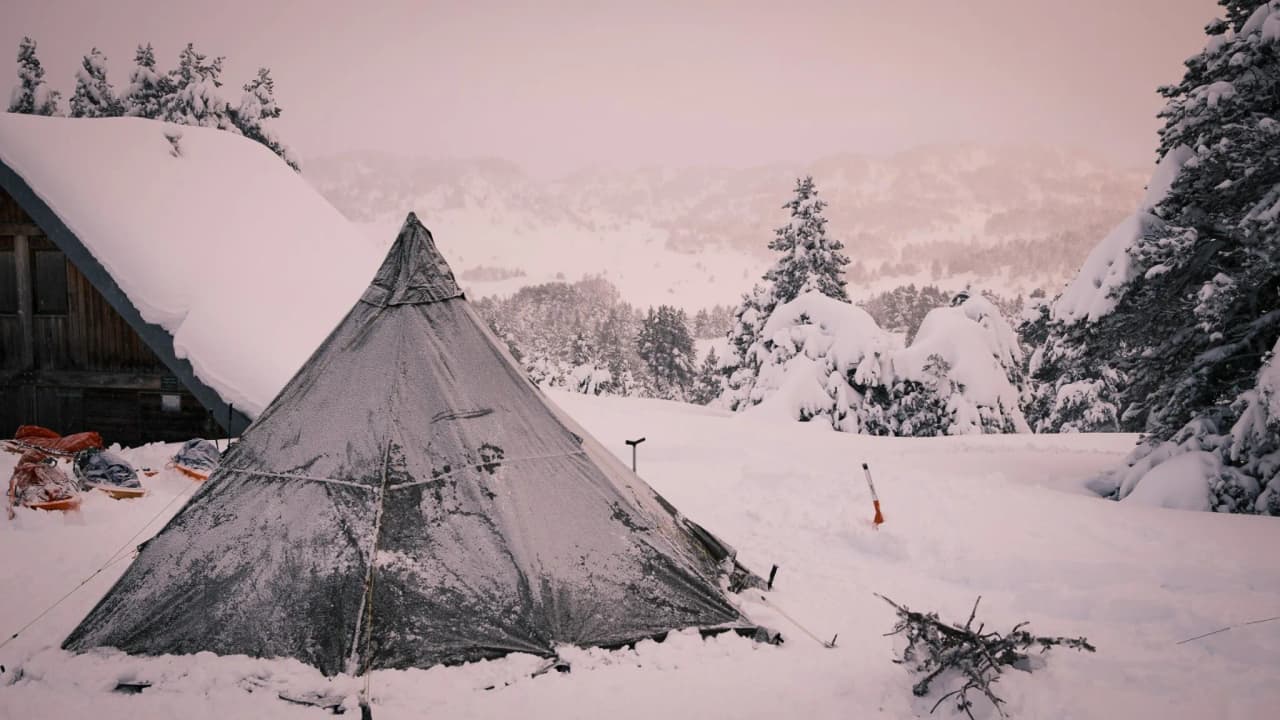 Bivouac sous un tipi enneigé, entouré de paysages sauvages du Vercors, invitation à l'évasion.