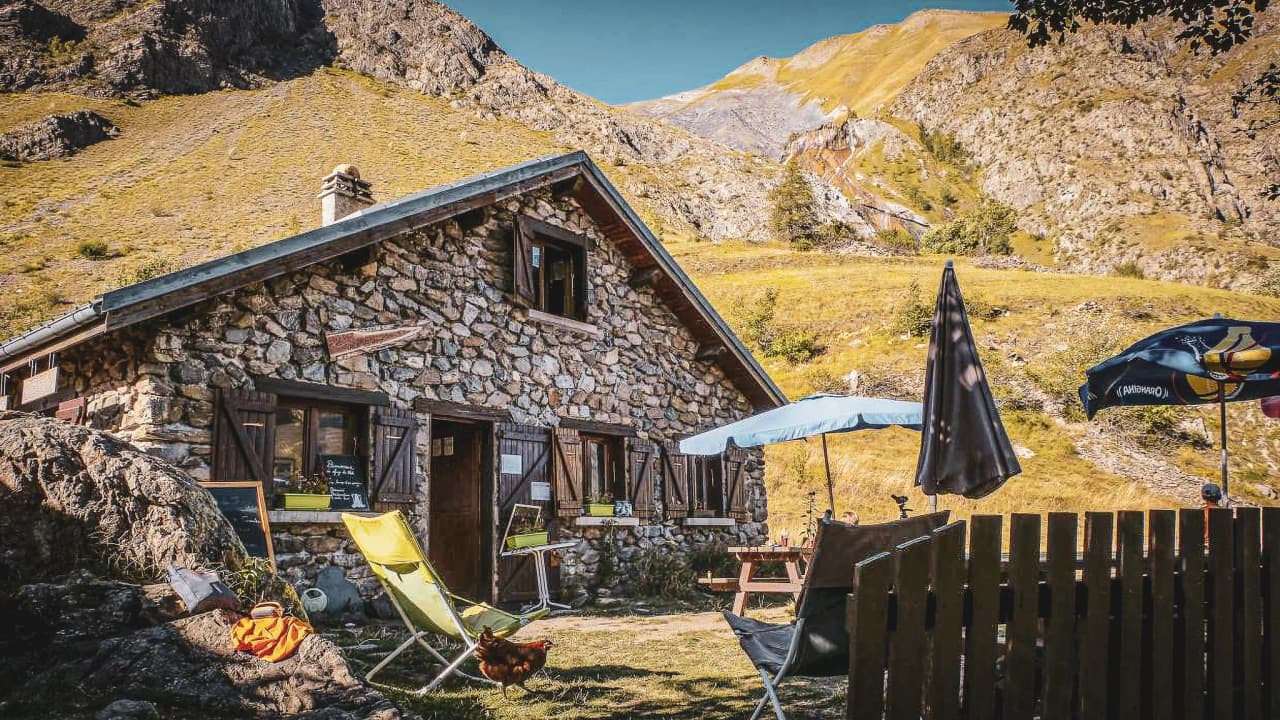 Stone Mountain hut in the heart of the Écrins, surrounded by lush green mountains. A haven of peace.