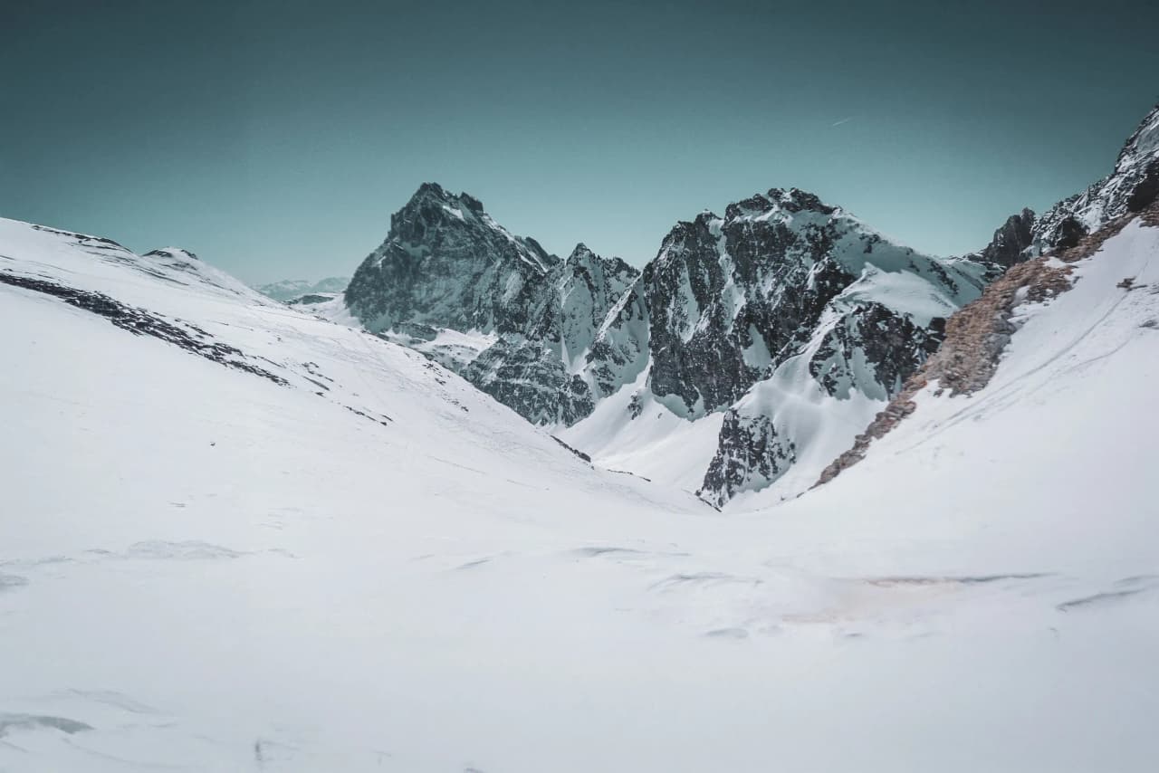 Paysage montagneux enneigé, majestueuses cimes du Mont Viso sous un ciel azur. Aventure en pleine nature.
