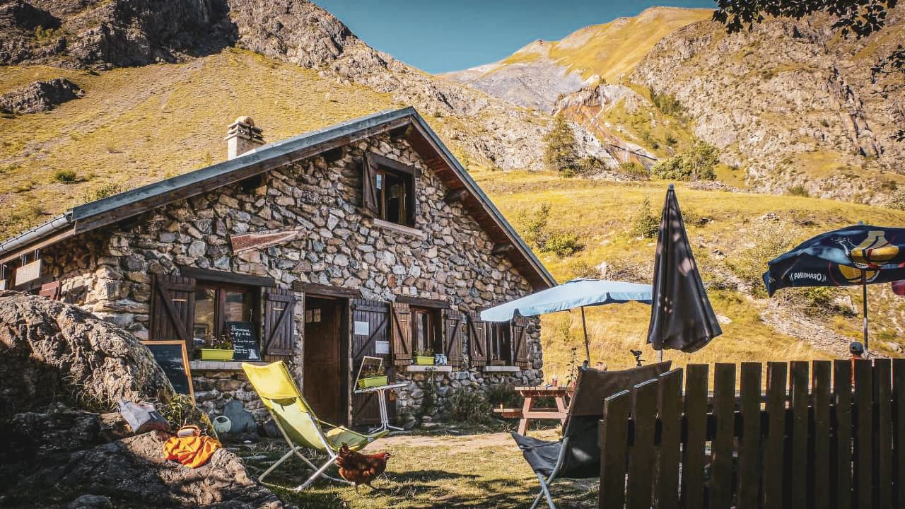 Refuge en pierre au cœur des Écrins, avec vue sur les montagnes, invite à la sérénité et l'aventure.