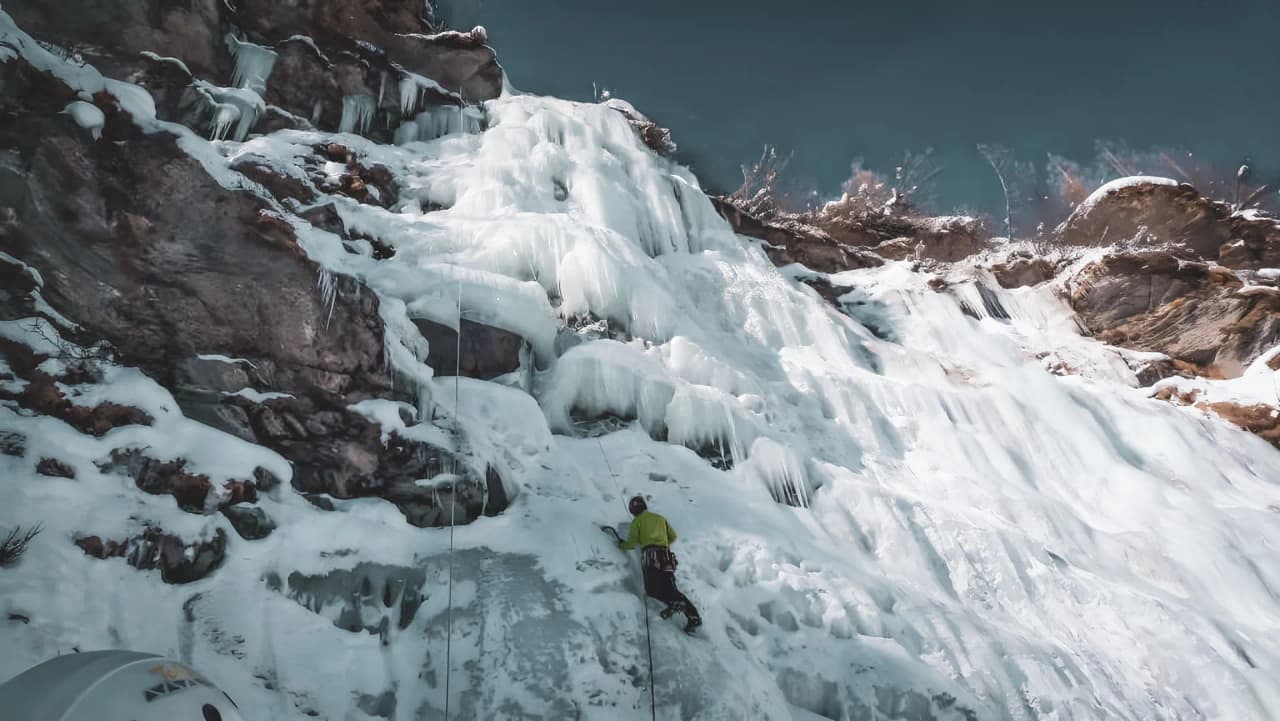 Escalade sur une cascade de glace majestueuse, entourée de paysages alpins enchanteurs.