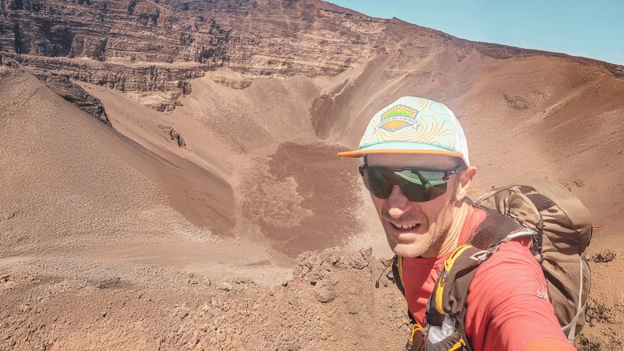Athlete on top of a volcano in Auvergne, spectacular view of volcanic landscapes.