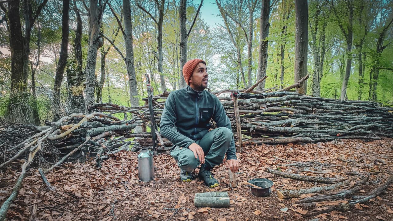 A man in the wilderness, learning survival techniques in the greenery of the Vercors.