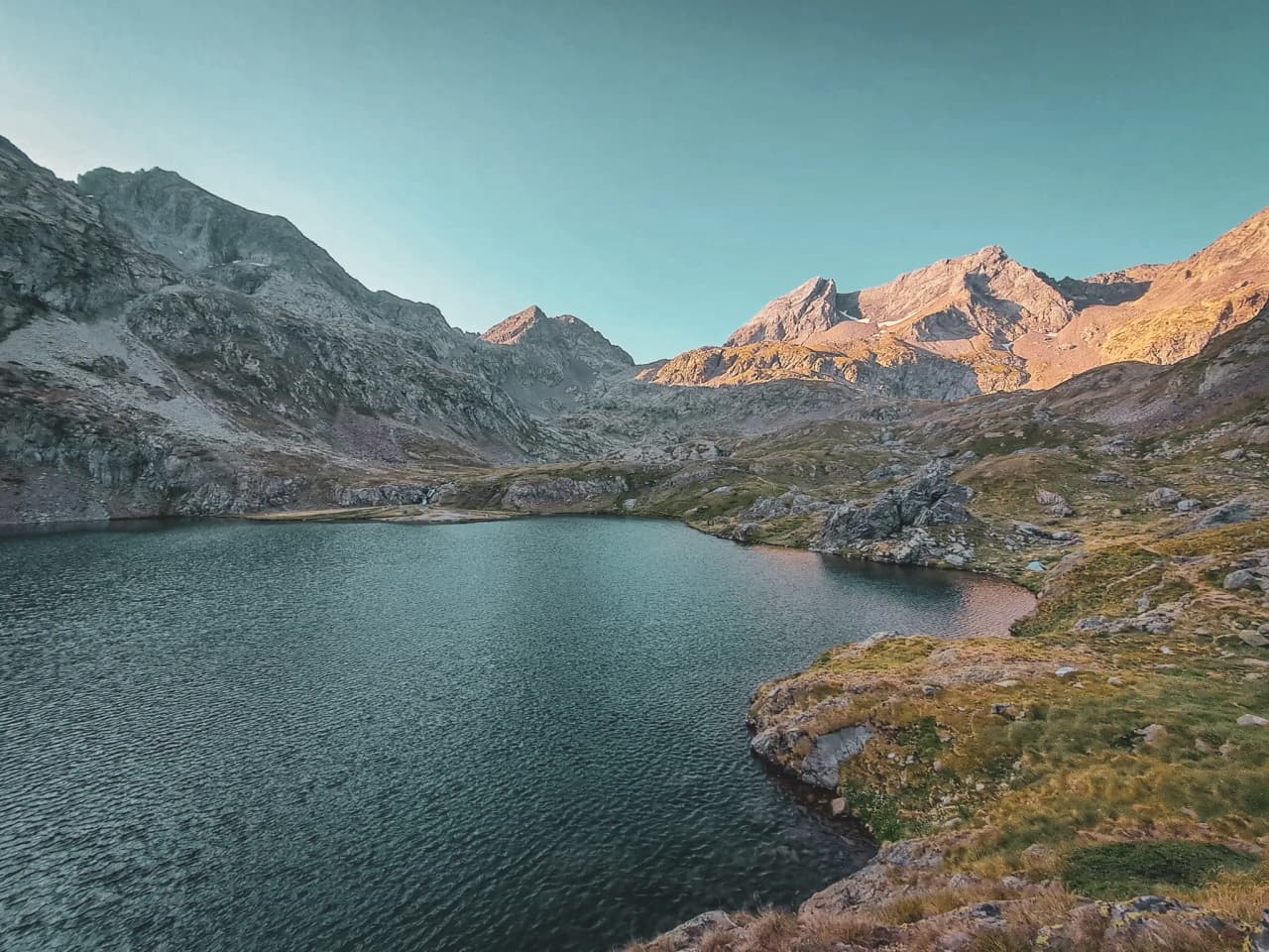Lac paisible entouré de montagnes majestueuses au cœur des Pyrénées, invitation à l'évasion.