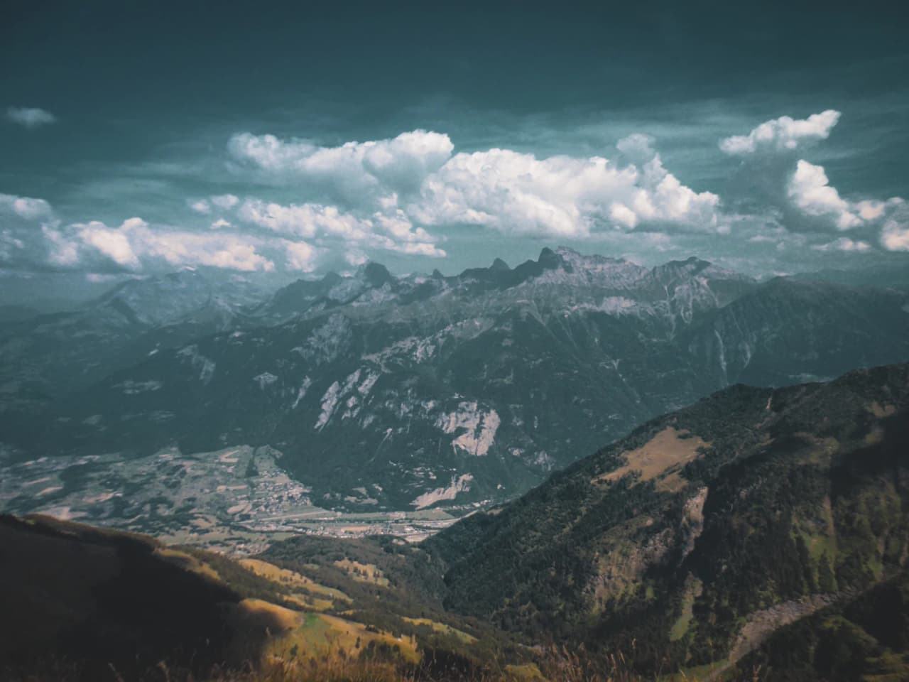 Alpine panorama of the Dents du Midi, with majestic mountains and scattered clouds. An invitation to adventure.