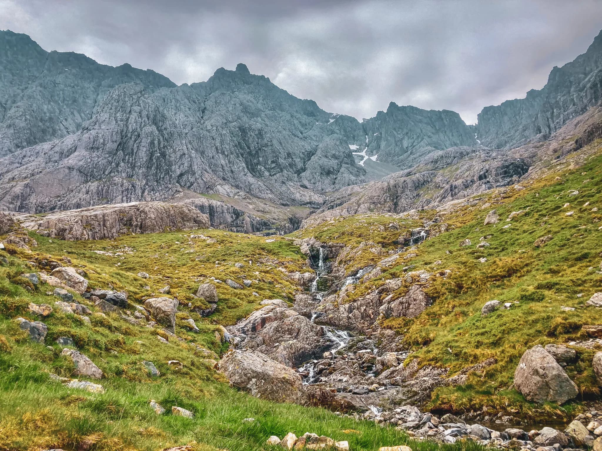 Het wilde landschap van de Schotse Hooglanden, met majestueuze bergen, beekjes en weelderige groene weiden.