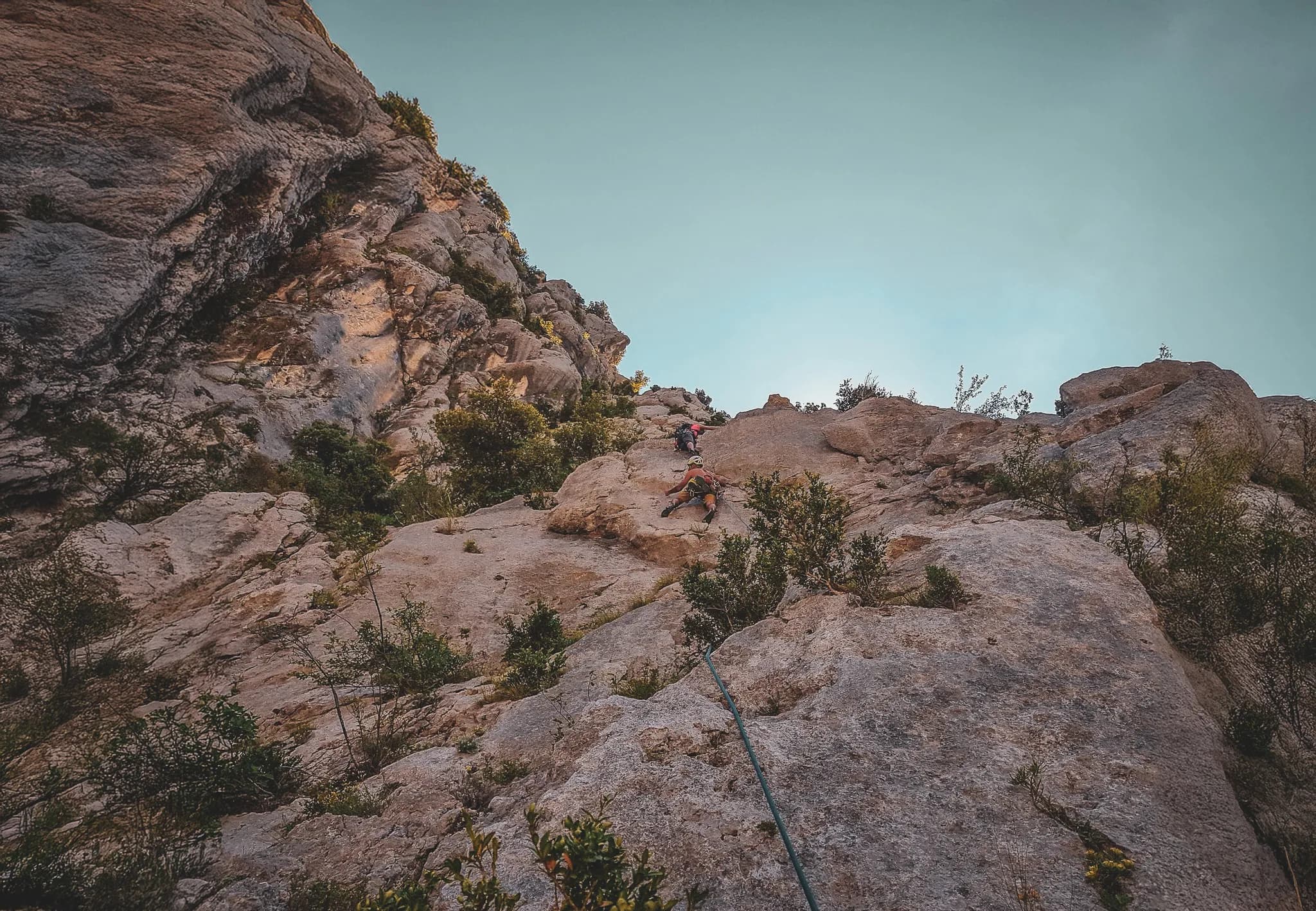 Climbers tackling the majestic cliffs of the Gorges du Verdon under an azure sky.