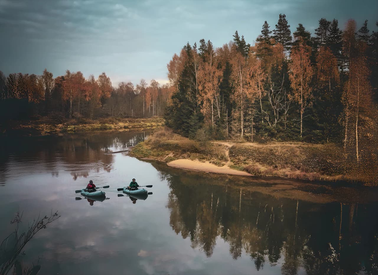 Two packrafters explore the rivers of Oulanka, surrounded by autumn landscapes.