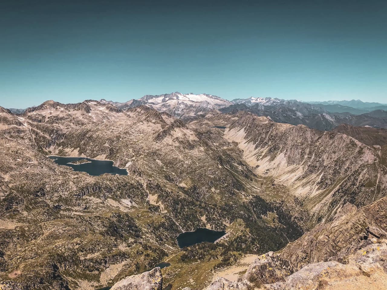 A majestic panorama of the Encantats mountains, dotted with dazzling lakes and azure skies.