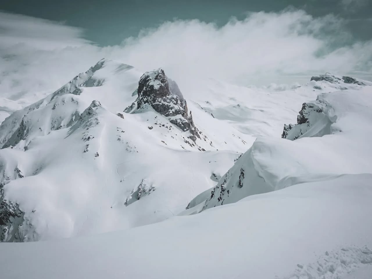 Paysage montagneux enneigé avec des crêtes majestueuses, invitant à l'aventure en ski de randonnée.
