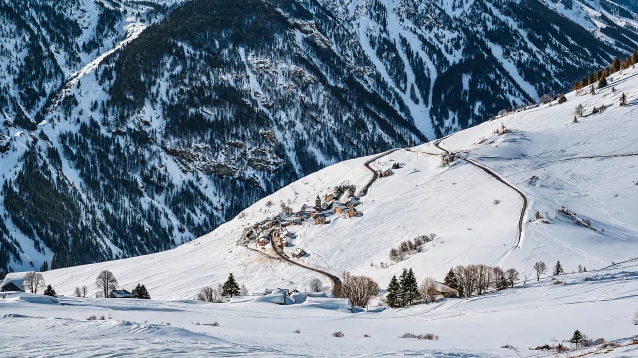 Een adembenemend winterlandschap met een schilderachtig dorpje in een besneeuwde vallei.
