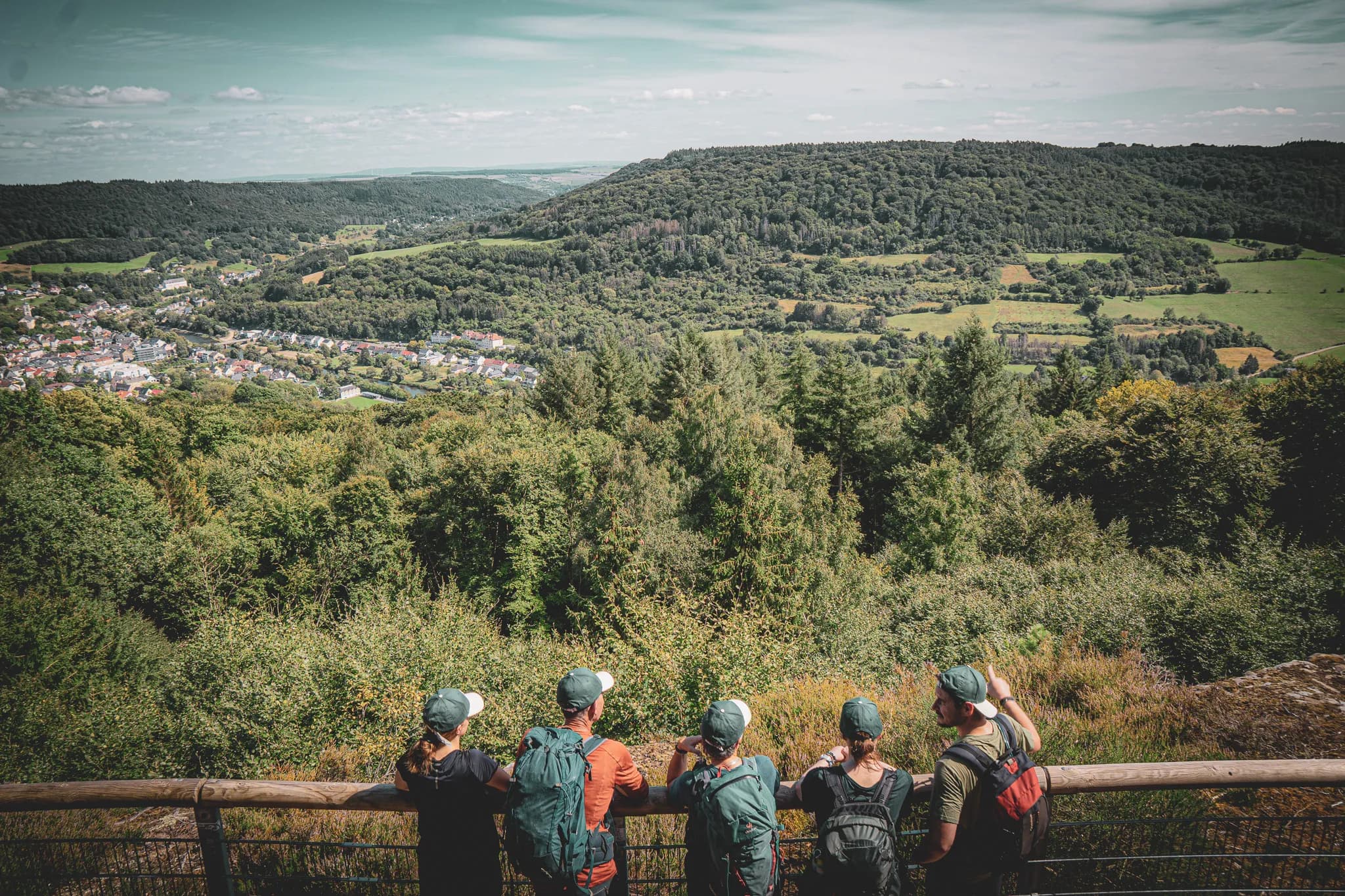 Een groep wandelaars bewondert het groene landschap van Luxemburgs Klein Zwitserland.