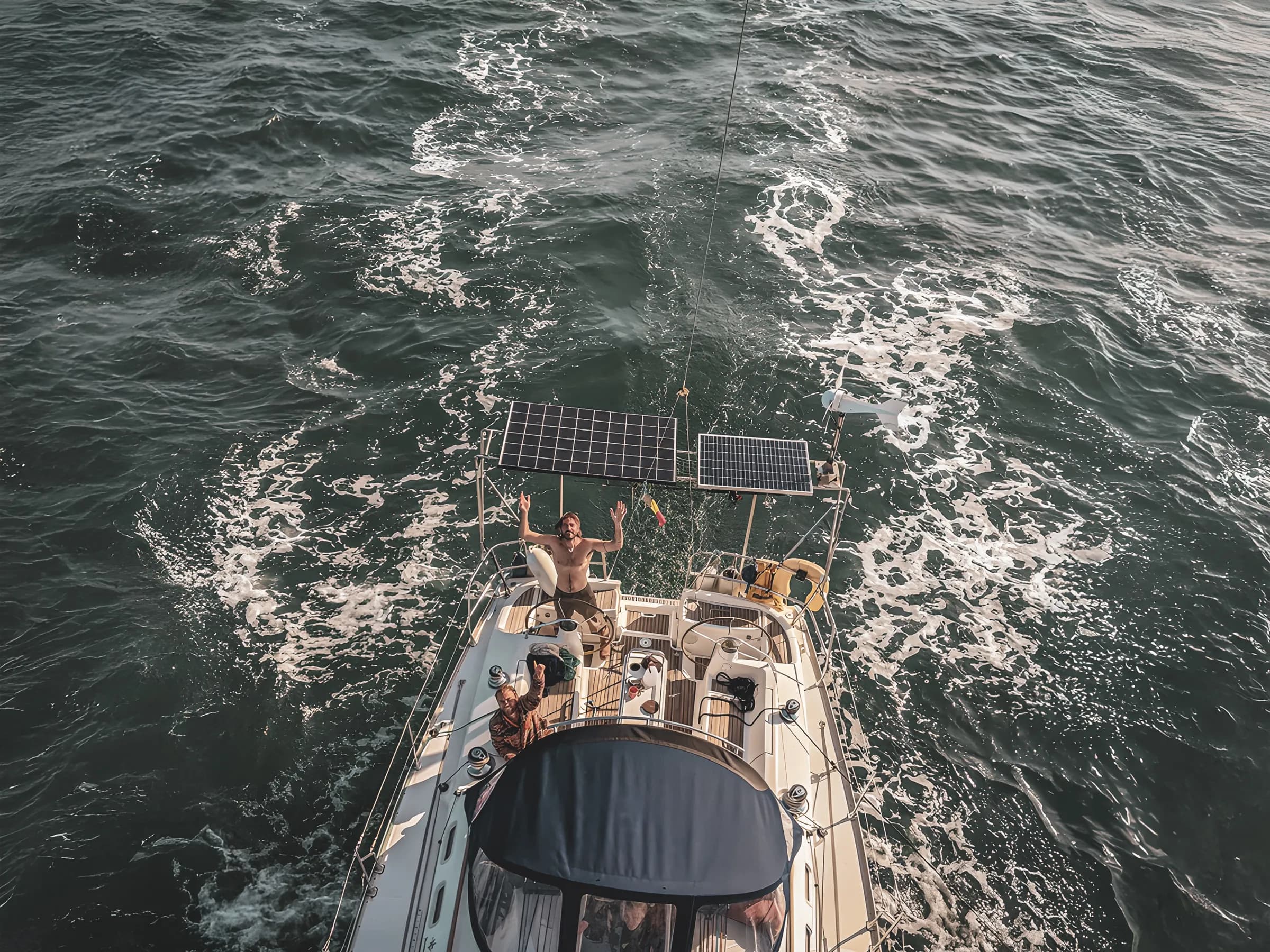 Un voilier naviguant sur des eaux turquoise, avec des aventuriers profitant du soleil et de l'air marin.