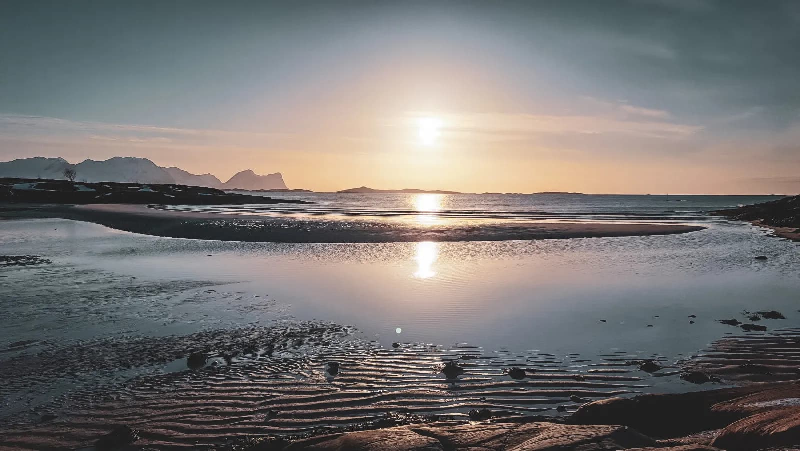Coucher de soleil sur les fjords de Senja, reflets magiques sur l'eau, paysage enchanteur.