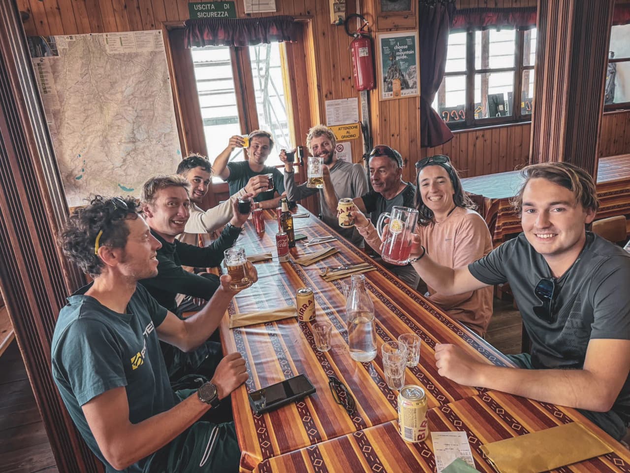 A group of friends raise a glass in an alpine Mountain hut after a day of adventure.