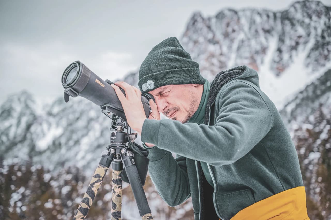 A photographer on snowshoes, capturing the beauty of the snow-covered Pyrenees.