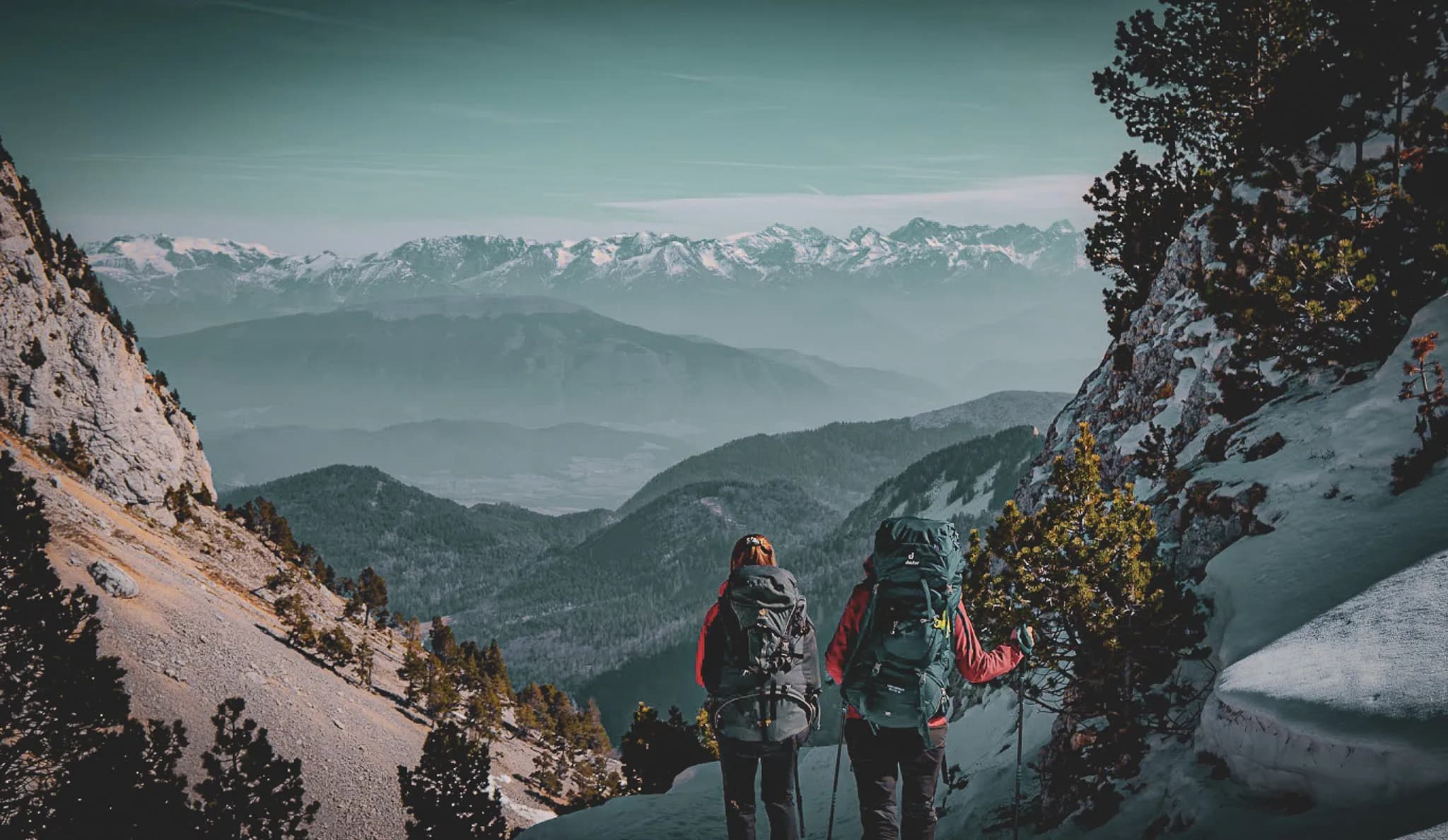Two hikers gaze at the majestic Vercors mountains, surrounded by unspoilt nature.