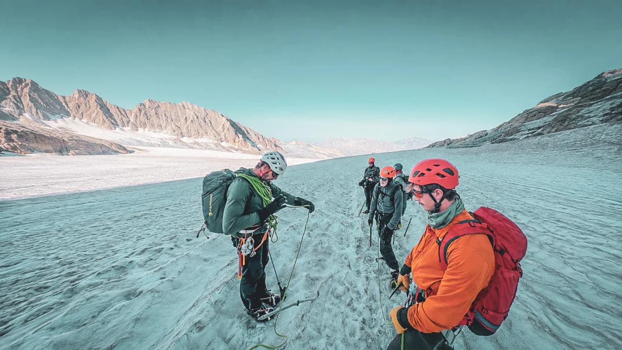 Cinq alpinistes sur un glacier de Chamonix, prêts à explorer les sommets majestueux.