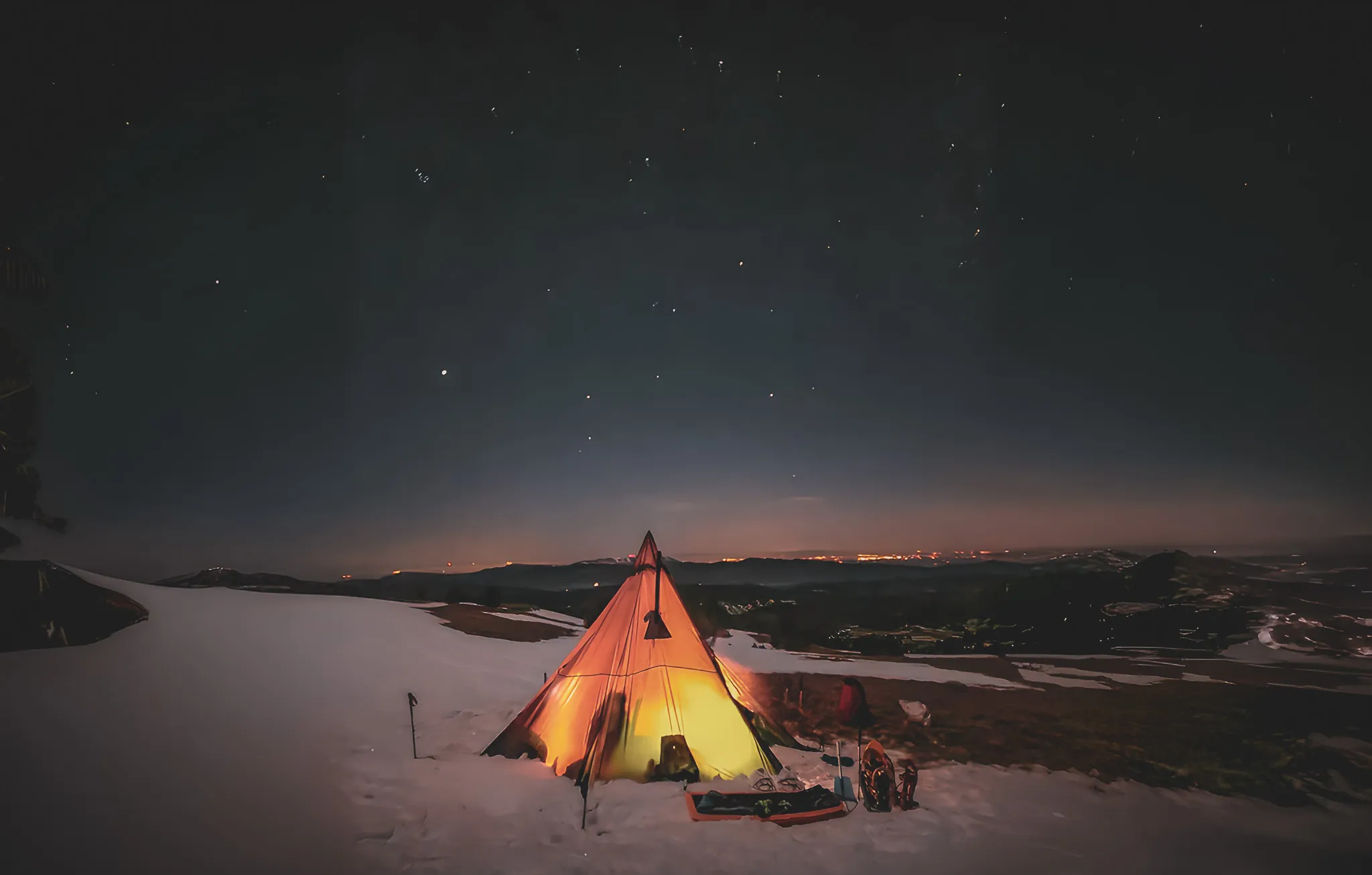 Bivak onder een met sterren verlichte tipi in de sneeuw, met uitzicht op de Vercors. Avontuur en sereniteit.