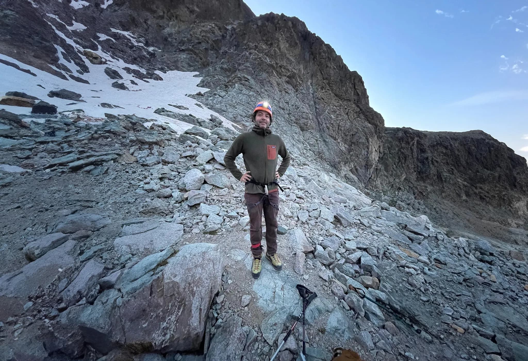 Alpiniste souriant sur un rocher, prêt à conquérir les sommets des Écrins. Aventure à portée!