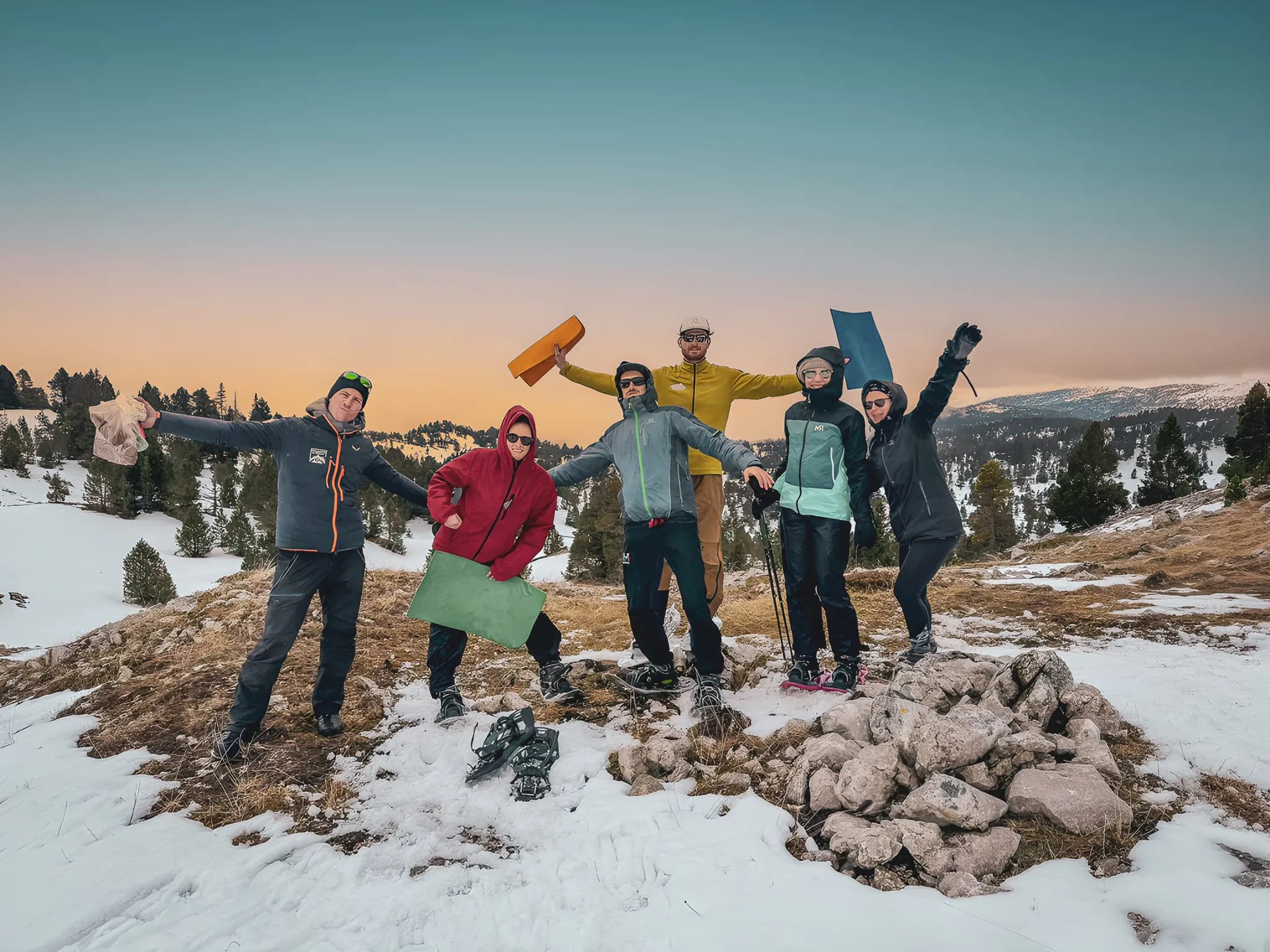 Een vrolijke groep op sneeuwschoenen, omringd door de besneeuwde landschappen van de Vercors bij zonsondergang.