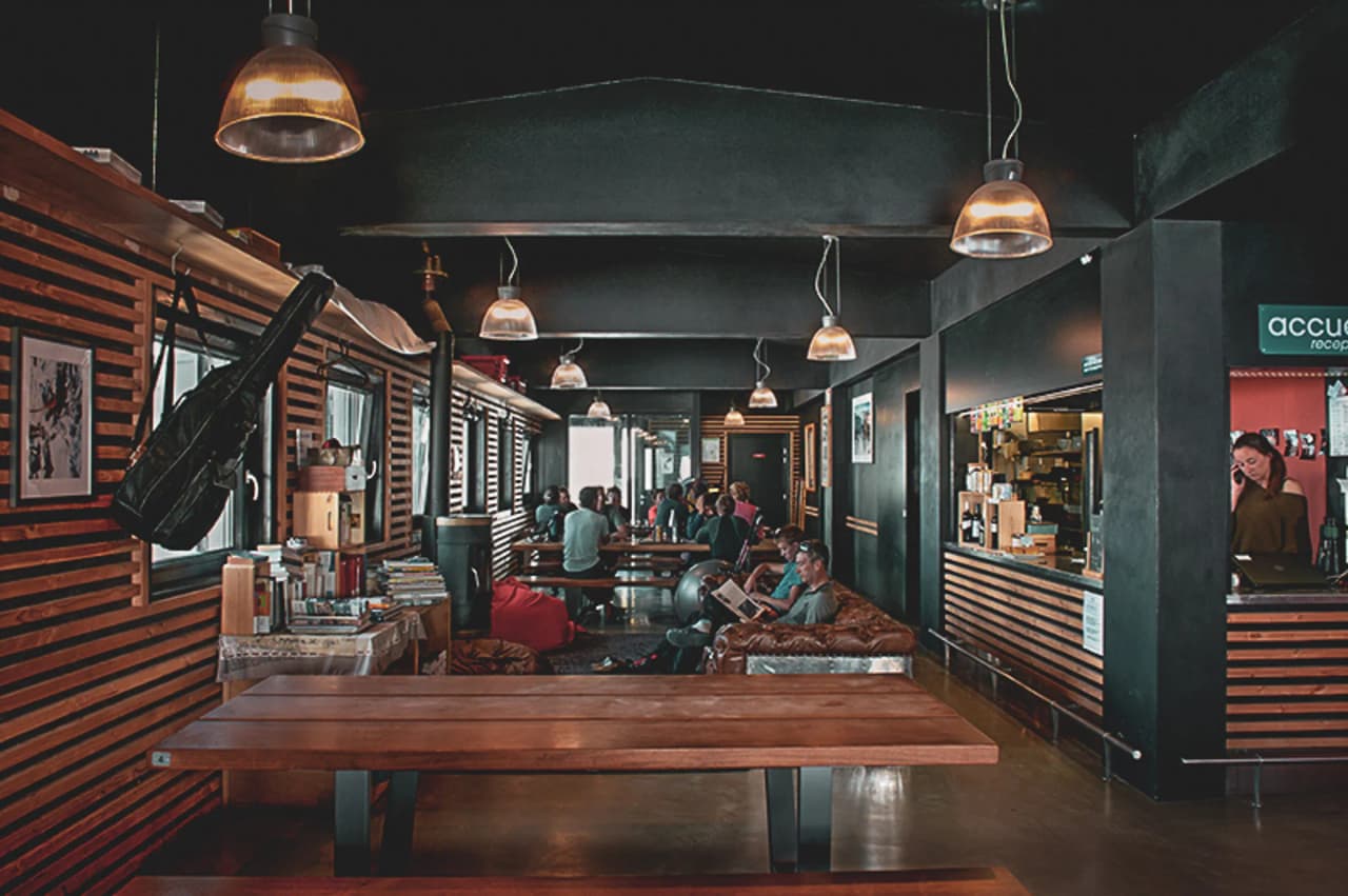 Gezellig interieur met houten tafels, vriendelijke sfeer, perfect om te ontspannen na een wandeling.