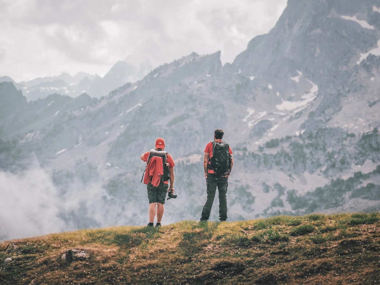 Deux randonneurs admirent les majestueuses montagnes des Pyrénées, prêts pour l'aventure.