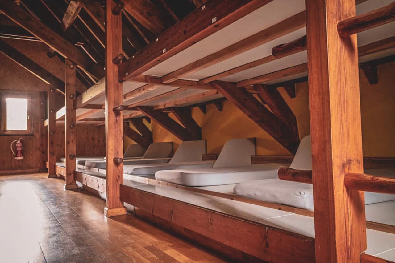 Cosy wooden Mountain hut with bunk beds, ready for an overnight stay after a mountain adventure.