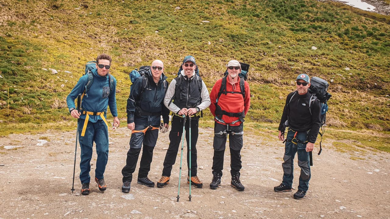 Five smiling hikers, ready to explore the glaciers of the Alps between Chamonix and Zermatt.