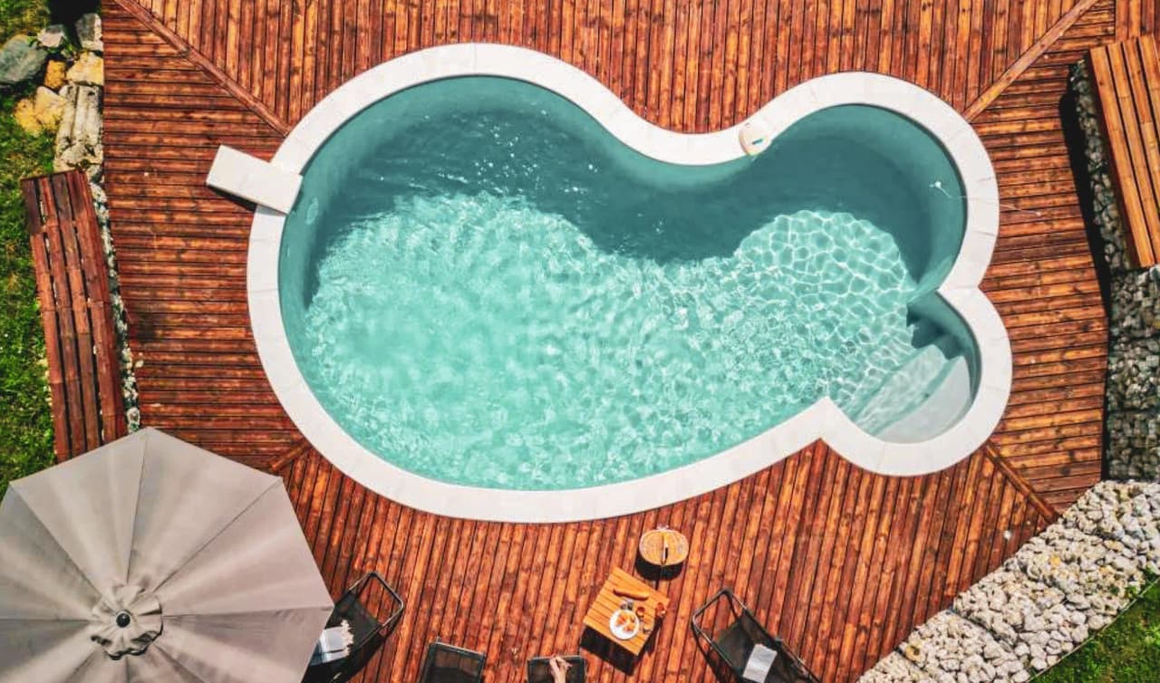 Immerse yourself in the serenity of a sunny pool surrounded by woods and greenery, ideal for relaxing.
